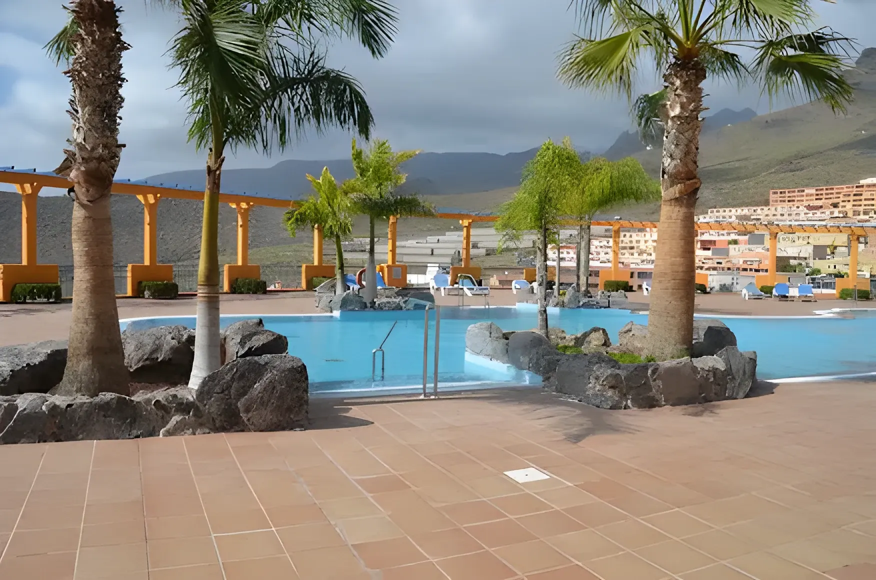 Piscina comunitaria rodeada de palmeras