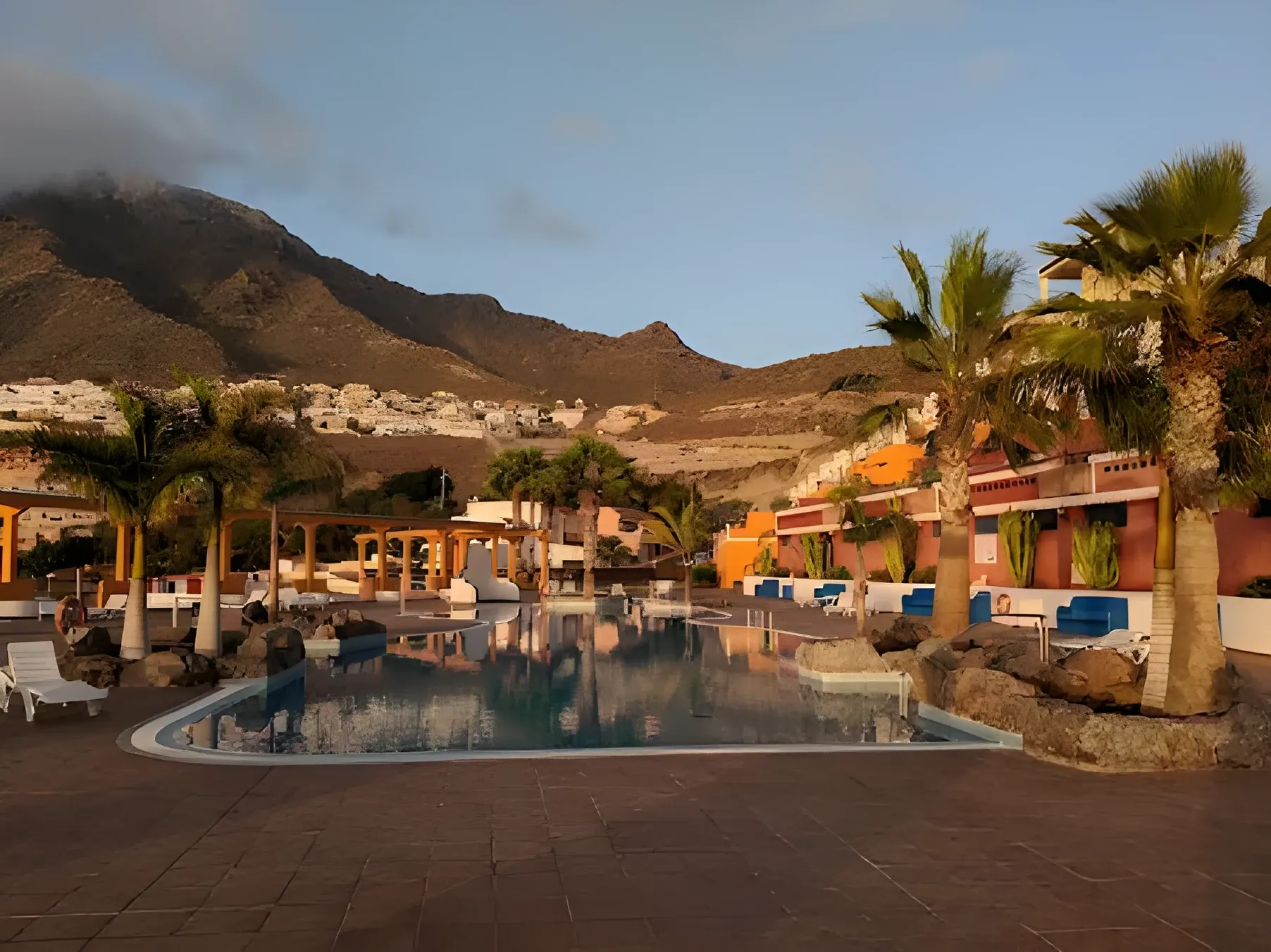 Zona de piscina y jardines al atardecer